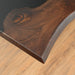 A sleek epoxy resin wood table with a dark wood grain and a flowing black epoxy resin river.