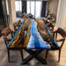 Live-edge golden camphor table featuring deep ocean-blue epoxy resin.