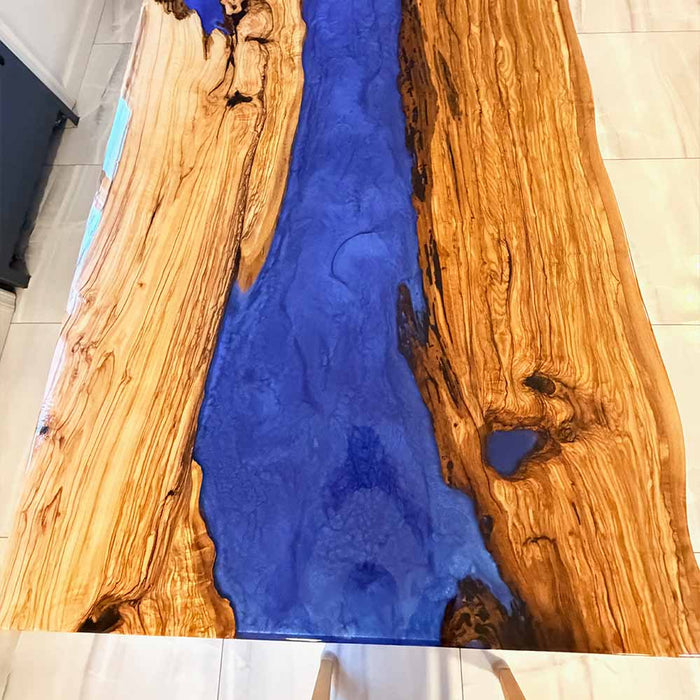 Premium live edge olive wood river table with deep blue epoxy resin for modern San Diego interiors.