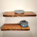 Two wooden shelves with decorative plates and a pot on a plain wall.