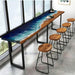 Custom resin wood counter-height bar table with stools, blending ocean-inspired blue tones and natural grain.