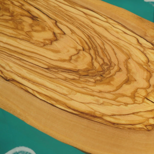 Round dining table with turquoise epoxy resembling ocean waves.