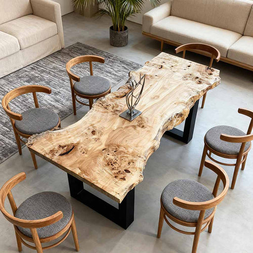 Wooden dining table with natural finish surrounded by matching chairs in a modern living room.
