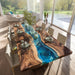 Dining table with a unique design featuring a blue resin river in a modern living room.