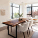Dining room with a wooden table and white chairs near large windows.