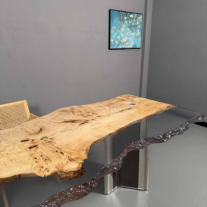 Wooden console table with glass top in a room with a painting on the wall.