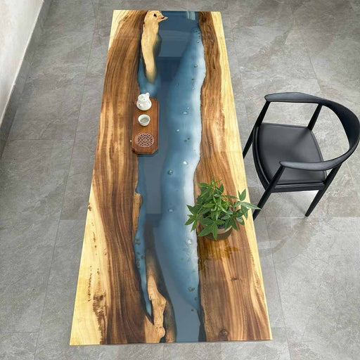 Wooden table with blue resin inlay and black chair on gray floor