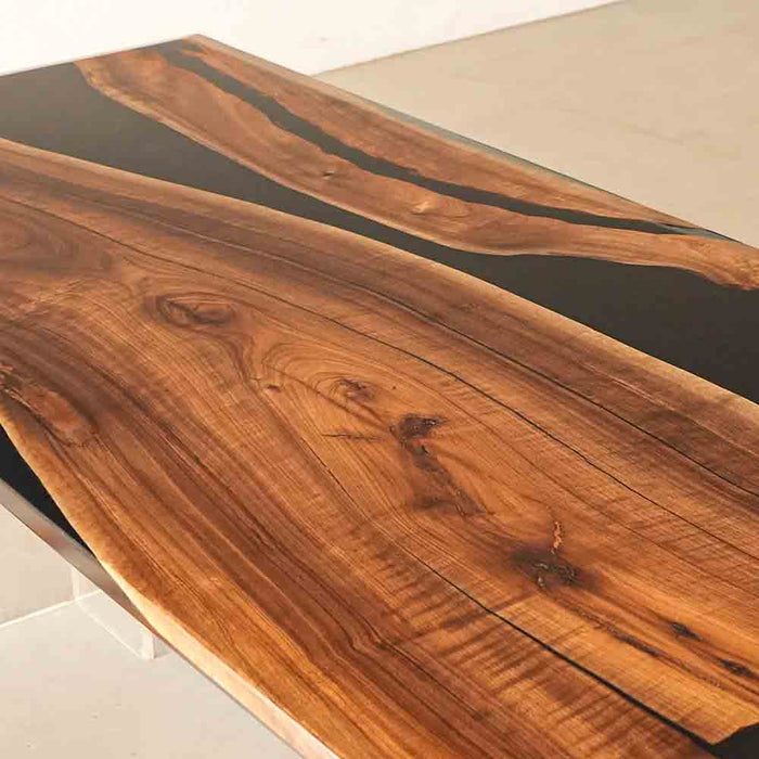 Wooden table with black resin inlay on a white background