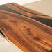 Wooden table with black resin inlay on a white background