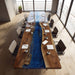 Long wooden table with a blue resin river in a modern office setting