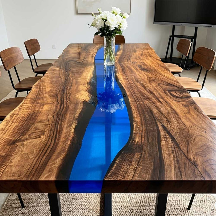 Coastal inspired artisan furniture featuring a bright blue resin river table styled with decorative books and sculptures.