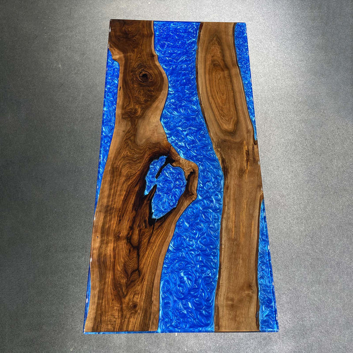 Wooden slab with blue resin inlay on a gray background