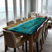 Dining table with a unique blue and green resin design in a modern living room.
