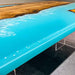 Golden Camphor light blue epoxy resin dining table styled in a contemporary dining room.