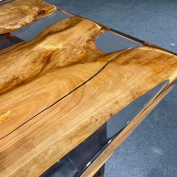 Wooden table with a natural grain pattern on a blue carpeted floor.