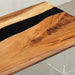 Walnut epoxy resin dining table styled in a contemporary dining room.