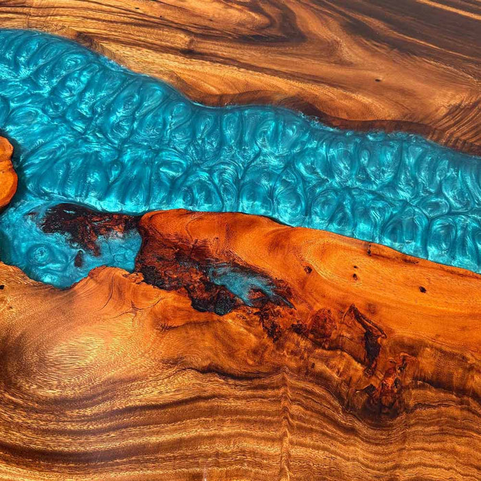Wooden surface with a blue resin river running through it