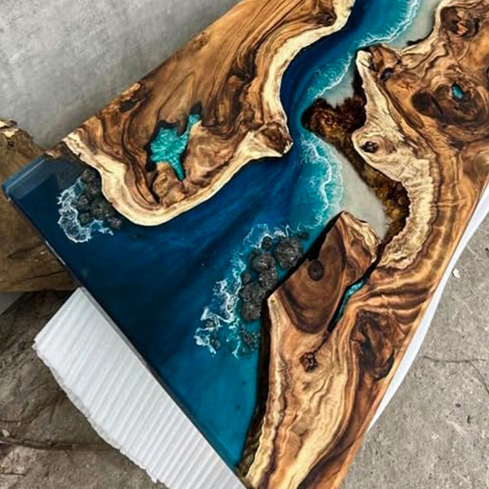 Wooden surface with blue resin flowing through it, resembling a river.