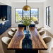 Modern dining room with a wooden table and chairs, large windows, and blue cabinets.