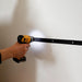 Person using a power drill to install a belt on a white wall.
