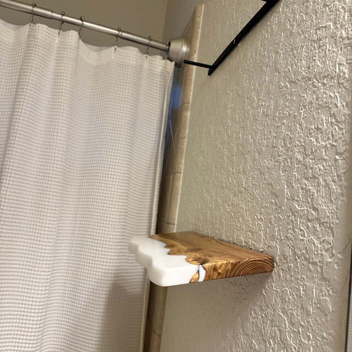 Shower curtain rod with a wooden and white shelf against a textured wall.