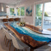 Modern kitchen with a unique dining table featuring a blue resin design.