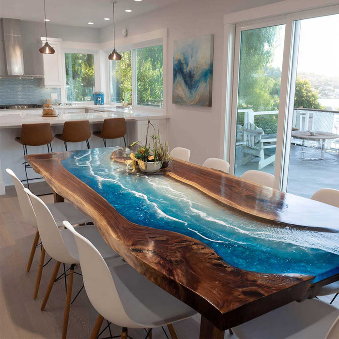 Modern kitchen with a unique dining table featuring a blue resin design.