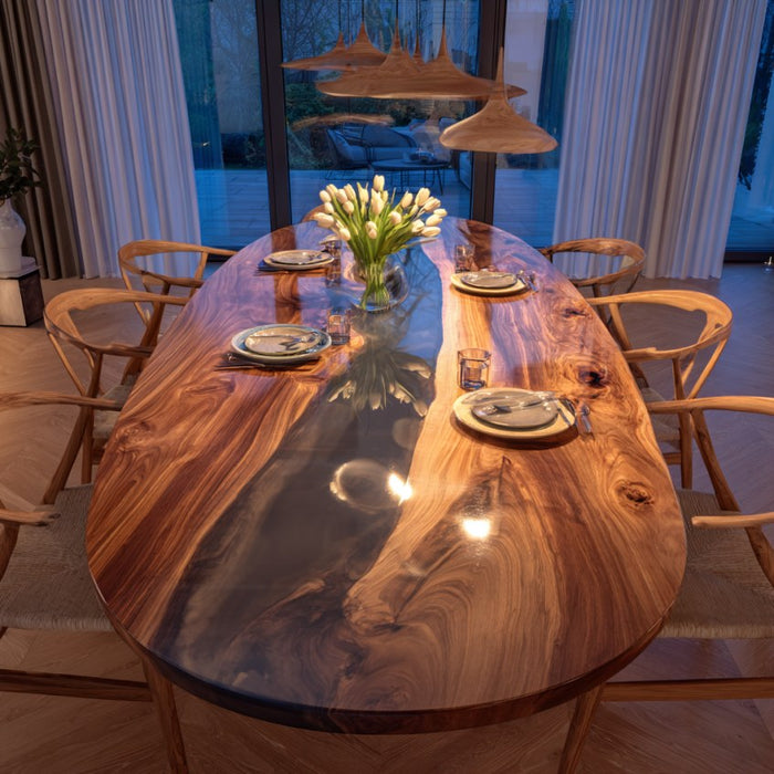 Dining room with a wooden table and chairs, featuring a vase of white flowers.