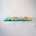 Decorative shelf with a natural wood and turquoise resin design on a white background