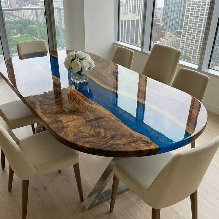 A stunning oval resin river table surrounded by cream chairs with a city view background.