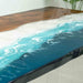 Tabletop with blue resin design resembling water on a wooden surface
