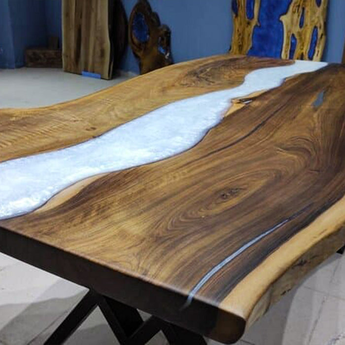 Wooden table with a white resin flow design in a room with blue walls and decorative items.
