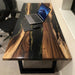 Modern executive office desk made of solid walnut wood and black epoxy.