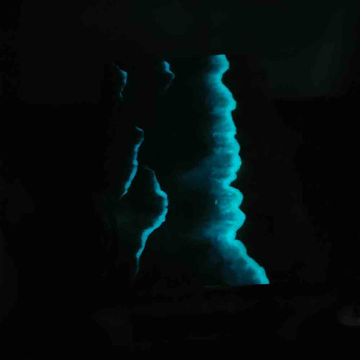 Blue glowing rock formation in a dark cave