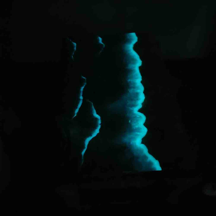 Blue glowing rock formation in a dark cave