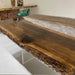 Modern dining room featuring a large wood and resin river table with industrial metal legs.