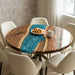 High-end resin and wood coffee table styled with croissants and coffee in a bright, minimalist interior.