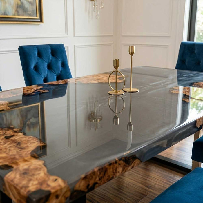 A handcrafted resin and wood table paired with velvet blue chairs in a sophisticated dining room.