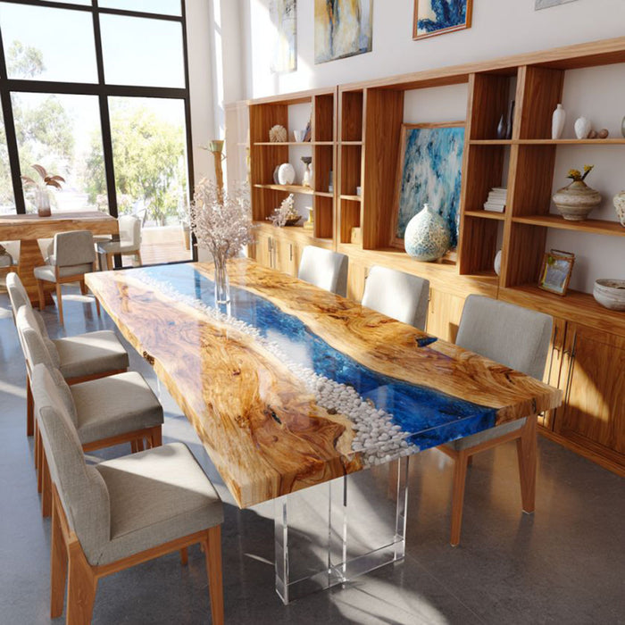 Dining room with a long wooden table featuring a blue resin inlay, surrounded by chairs.