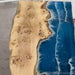 Modern ocean wave epoxy dining table with natural wood grain designed for farmhouse style dining rooms and family gatherings