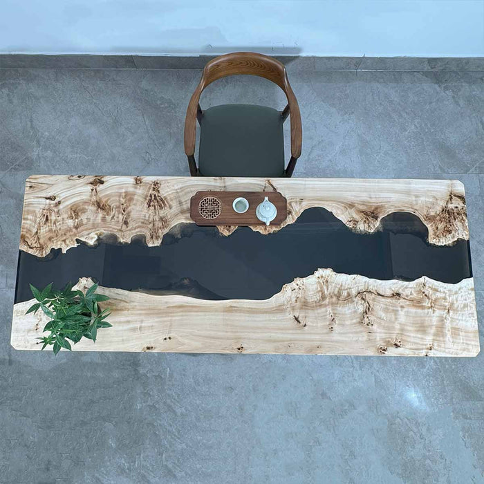 Wooden desk with natural finish and embedded decorative elements on a gray floor.