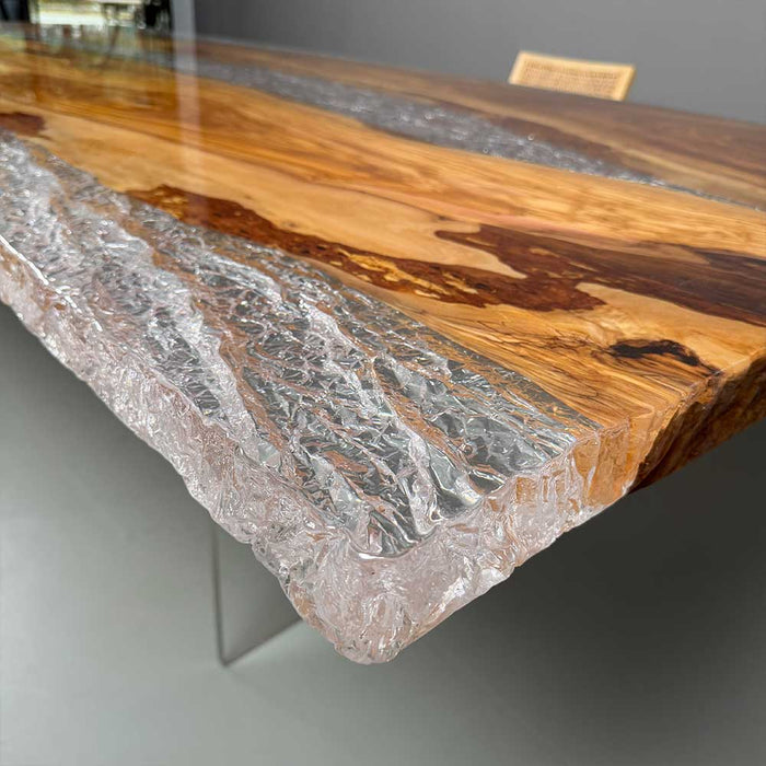 Olive wood resin dining table showcased in contemporary restaurant or luxury dining room setup.