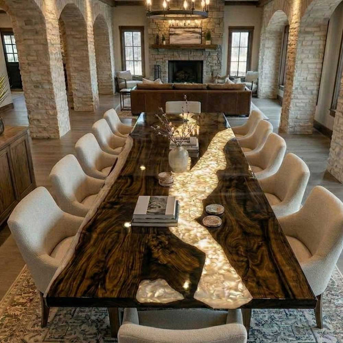 A large modern rustic conference table with a white river design and integrated lighting, set in a spacious room with stone arches.