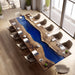 Long wooden dining table with blue central river design in a modern room.