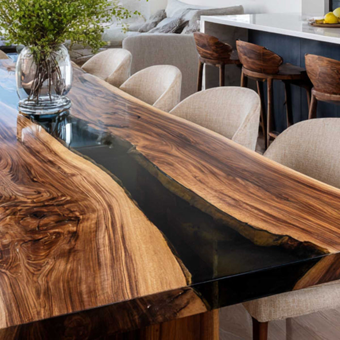 Wooden dining table with black resin finish in a modern living room setting.