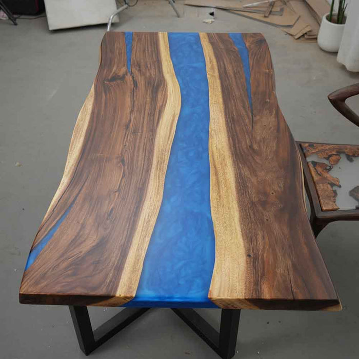 Wooden table with blue resin inlay in a workshop setting