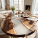 Wooden dining table with white resin inlay in a bright room with natural light.
