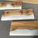 Three wooden slabs with a natural finish on a gray surface