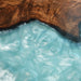 Natural black walnut wood grain contrasted with vibrant teal blue resin in a contemporary dining table