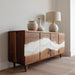 Wooden sideboard with marble-like inlay, accompanied by decorative vases and a lamp.